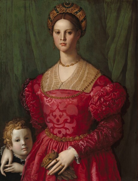 A woman wearing a crimson-red brocade dress and gold jewelry fills most of this vertical portrait, but her right hand, on our left, rests on the shoulder of a young boy tucked into the lower left corner of the panel. The woman and boy both have pale, white skin, and both face and look out at us against an emerald-green curtain that falls behind them. The woman has brown eyes, a straight nose, full pink lips, smooth cheeks, and a long neck. Her brown hair is pulled back under a turban densely embroidered with gold. The woman’s dress has puffed shoulders and decorative slashes on the sleeves. One gold chain rests on her throat and the other falls over her chest. She wears long gold earrings, a gold belt, and two gold rings. She holds a brown leather glove in her left hand. The boy’s face is even with the woman’s waist, and he raises his left hand to hold hers, which is draped over his shoulder. He has curly blond hair and dark eyes, and he wears black with a ruffled white shirt just visible at his collar.