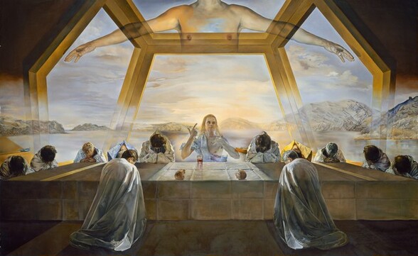 One transparent, ghostly man sits and twelve more people wearing long robes bow over a long table set under a floating, surreal structure in front of a watery landscape in this horizontal painting. The people all have light or tanned skin. At the center of the table opposite us, a man, Jesus, sits facing us with his left hand, to our right, touching his chest and his other hand raised with the thumb and index finger pointing upward. He has long, blond hair, dark brows, and his square jaw is cleanshaven. A piece of white drapery wraps over one shoulder so half of his chest is bare. His body is outlined with light but is transparent so we see the landscape beyond the table through him. Three men are spaced evenly, shoulder by shoulder, to each side of Jesus on the far side of the table. A pair of men sit at each narrow end, and two men sit on our side of the table, one to either side of Jesus. The men on our side kneel at the table, so presumably the rest do as well. They bow their heads low over their praying hands, which rest on the table. Ten of the men wear silvery-white robes. One man to our left wears a lapis-blue cloak and one to our right wears bumblebee yellow. Eight of the men have dark hair, three have gray hair, and one is blond. The table spans the width of the painting, with the short ends to each side receding sharply back in space so there is room for the men there. The parchment-white cloth covering the table is creased deeply where it had been folded. Two pieces of a round loaf of bread, torn in half, are to either side of Jesus near the edge of the table closer to us. A glass tumbler with red liquid sits near Jesus. The scene is lit from the landscape beyond the table, so the people are slightly backlit, and the shadows and the red glow from the glass extend toward us. A structure above the table is suggested by a floating form of interlocking, golden shapes, like an oversized honeycomb, to create a dome-like space. Coffee-brown areas at the upper corners of the painting suggest a ceiling, but the structure fades to transparency as it nears the table. A shimmering body of periwinkle-blue water stretches from behind the table to a row of low, gossamer-white, rocky mountains along the horizon in the distance. One empty, golden yellow rowboat floats in the water, seen past Jesus's left elbow, and a second, indigo-blue boat has been pulled onto a sandy shore to our left. The sky above is topaz blue around a warm, yellow glow emanating from Jesus. A few taupe and cream-white clouds float across the sky. The artist signed the painting in dark brown on the tablecloth in the lower right: “Gala Salvador Dali 1955.”