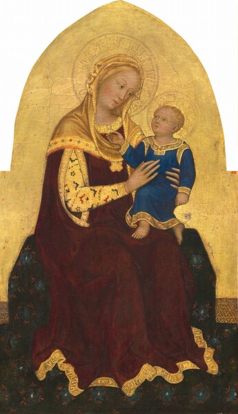 A young woman, holding a baby in her lap, sits on a wide bench draped with a patterned midnight-blue fabric in this vertical panel painting. The panel is rectangular at the bottom and becomes a pointed arch at the top. The woman and baby both have pale skin tinged with peach, and halos inscribed on a gleaming gold background. The woman’s body is angled to our right and she tilts her head in that direction to look down at the child. She has a slender, oval face, with hazel-brown eyes under thin brows, a long nose, and coral-pink lips. A sliver of blond hair peeks out from the honey-gold cowl that covers her head, neck, and shoulders. The cowl is layered over her gold-trimmed, burgundy-red robe, which has an opening through which her right arm, closer to us, reaches to support to the child. That arm is covered by a long, gold sleeve patterned with scalloped brick-red and marine-blue designs and smoke-gray flowers. The word “MATER” is inscribed on her neckline and “AVE MARIA GRATIA PLENA DOM TECV BEN” along the bottom hem. On the woman’s lap, the child is angled to our left with the woman’s slender hands wrapped around his torso. His mouth is slightly open as he tilts his head up to look at her. His right hand, on our left, reaches up to gesture at her neckline. He has wavy, blond hair and hazel eyes under faint brows, a small nose, and peach-colored lips set in a round face. He wears an ankle-length, cobalt-blue tunic trimmed with bright gold. The fabric on the bench is covered with cobalt-blue and crimson-red flowers, and pools around the seat and across the floor.