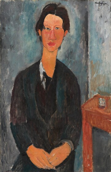 Shown from the lap up, a cleanshaven man with black hair and dark clothes faces us as he sits with his hands resting together in his lap in this stylized, vertical portrait painting. The man's features, clothing, and the room are painted with areas of mottled color with visible brushstrokes, so many details are indistinct. The man has peach-colored skin, and his facial features are outlined. He has dark eyes that look at us or slightly up, under thin, arched brows. One eye is a little higher than the other, and the two halves of his long face do not quite match. He has a wide nose, and his full, dark rose-pink lips are closed. His hair is parted down the middle and is brushed down to meet his ears. He has an elongated neck, and his narrow shoulders slope down. He wears black pants and a black coat over a dark teal-green vest. A white shirt is visible along his neckline, and an area of black could be the knot of a tie. He holds the fingers of one hand in his other, both hands resting in his lap. A loosely painted, brown table sits next to the man to our right, and an area of slate blue and white could be a glass on the table. A vertical line in the background behind the man, to our right, probably indicates the corner of the room. The walls are painted with strokes of smoke gray, ocean blue, and some parchment white. The artist signed the work in dark letters in the upper right corner, “modigliani.”