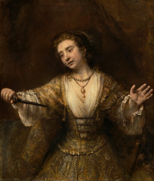 Shown from the thighs up, a pale-skinned woman looks down and off to our left as she holds the pointed end of a dagger toward her chest in this vertical painting. Her lips are slightly parted, and her arms are spread wide as holds the hilt of the dagger in her right hand, to our left. Her hooded, dark brown eyes are rimmed with red. Her head tilts to our left, her pale lips parted. There are gray shadows at the corners of her mouth and along her jawline. Her brown hair is pulled back under a cloth covering painted with white flecks to suggest shiny thread or possibly jewels. She wears a long, tawny-brown gown with diaphanous sleeves. The bodice is laced up over a cream-white undergarment with a deep V neck and voluminous sleeves with unfastened cuffs near her wrists. She wears a large, teardrop-shaped pearl in the ear we can see and two necklaces. One necklace is a strand of pearls, and the other is a gold and possibly jeweled pendant with another teardrop pearl hanging from a cord. A gold belt drapes around her hips over a narrow waist. She is warmly lit from the upper left and set against an earth-brown background. The artist signed and dated the center left, “Rembrandt 1664.”