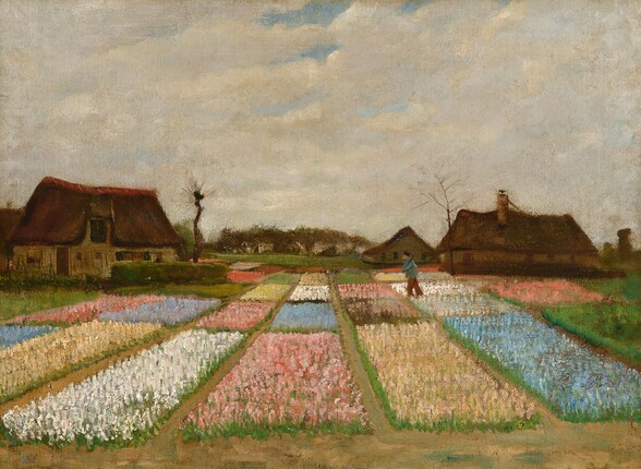 Rectangular plots of flowers, each in a single color, stretch toward us below a sky nearly filled with cream-white clouds in this horizontal landscape painting. Together, the monochromatic plots create the impression of a patchwork quilt, with large areas of pale pink, butter yellow, bright white, and baby blue. A person walks across the plots to our right. The horizon line comes almost halfway up the painting and is lined with dark brown houses with tall, pitched roofs. Two barren trees twist into the cloudy sky. The loose, short, parallel brushstrokes and touches of paint create a soft, hazy effect.