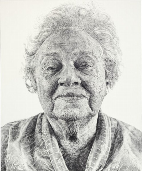 Shown from the shoulders up against a white background, an elderly woman gazing at us fills this black and white vertical portrait painting. The portrait is created with tones of light and silvery gray with darker gray in the shadows. Short, wavy, flyaway hair stands off the top and sides of her head, and she looks at us with half-closed, small eyes under arched brows. Her wide mouth is closed, and the corners are pulled back in a slight smile. Deep wrinkles run down from the corners of her mouth to her drooping jowls. There is a deep, round hollow, shaded black, at the base of her neck, which is surrounded by a starburst of fine wrinkles. She wears a light gray, V-neck shirt with white stripes and stylized flowers. The overall impression is that this portrait is painted with delicate tones of gray, but closer inspection reveals that it was made with inked fingerprints. The whorls of fingers in black ink, pressed lightly or layered against the canvas, are visible.