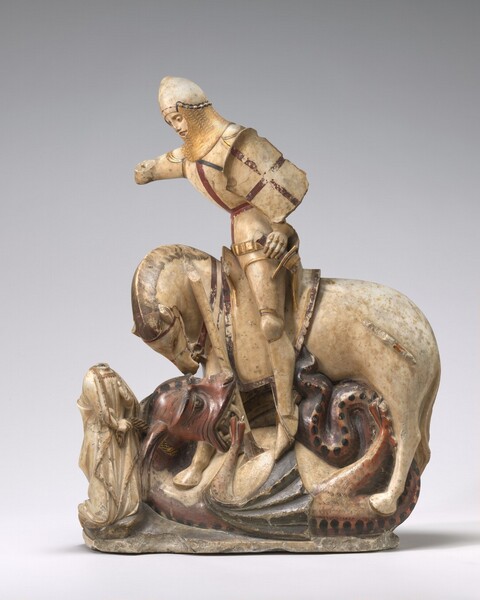Carved from cream-white alabaster stone, this free-standing sculpture shows an armored knight sitting atop a horse, which straddles a curled up, snarling dragon in front of a kneeling person. In this photograph, the bodies of the horse and man face our left in profile. The dragon is pinned on its back with its head under the horse’s mouth. There are some losses: the head of the kneeling person is gone, and parts of both of the knight’s arms are missing. The lance the knight holds and the sword at his hip are also fragmented. The knight leans forward with his right arm, farther from us, raised and a shield with a red cross is affixed to the opposite upper arm. His pointed, rounded helmet is lined with chain mail around the chin and neck. Simple bands in gold, red, and black decorate the knight’s armor as well as the saddle and bridle on the horse. The horse looks down at the dragon underfoot, his chin pulled sharply back. The dragon is painted burgundy red, and has a large head with a gaping mouth filled with sharp teeth and fangs. Claws tear at the horse’s legs as the knight drives the lance into the dragon’s body. The creature’s black wings are pinned under its body, and its dotted tail curls up between the hind legs. To our left, near the dragon and horse's heads, the kneeling person wears a gold-edged dress under a voluminous robe. One hand holds the black and gold striped band looping around the dragon’s neck, and the other is raised to that person’s chest. The stone under the people and animals is roughly carved, suggesting a rocky ground.