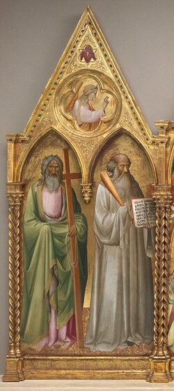 Two men with gray hair and beards stand under pointed arches with a winged angel in the triangular gable above, all against a gold background and set within a carved, gold frame in this vertical painting. This is the left wing of a three-panel triptych. The people all have pale skin with rosy cheeks, and the men’s faces are shaded with gray. Each man is set within his own pointed arch. Both of their bodies are angled very slightly to our right, toward the central panel, and they both wear long, voluminous robes. The man on the left gazes over our heads with dark eyes. His long, wavy gray hair frames his tan face, and tufts stick out the top and sides. His celery-green cloak is trimmed with gold, and it drapes over his blush-pink robe. He holds a wooden cross slightly taller than he is, tucked into his left elbow and leaning on that shoulder, to our right. In that hand, he holds a coiled, white rope. His other hand is held up by his waist but is covered with the green cloak. The man to our right looks in that direction. He is mostly bald with a fringe of curly hair over his ears. He wears a loose silvery-white robe and holds a bundle of rods in his right hand, resting on that shoulder. In his other hand, he holds an open book facing us so we can read the Latin text. Both men have halos carved into the gold background, and they stand on a floor patterned with gold and burgundy red. The outer columns of the panel have pairs of twisted shafts that support the gable, which has a circle carved into its center. In that roundel is an angel inside a four-lobed quatrefoil. Shown from the waist up, the angel has blond hair, a diadem, gold and crimson-red wings, and wears a shell-pink robe. Facing our right in profile, two fingers of the right hand are raised. Above the angel, a face is surrounded by blood-red wings, set within a shape that has three lobes alternating with three points. Barely discernable, the panel is inscribed across the bottom below the saints, “S. ANDREAS AP L U S; S. BENEDICTUS ABBAS.” The Latin text in the book reads, “AUSCU LTA.O FILI.PR ECEPTA .MAGIS RI.ET.IN CLINA.AUREM CORDIS.T UI A MONITIONE M.PII.PA TRIS.LI BENTE R.EXCIP E.ET.EF.”