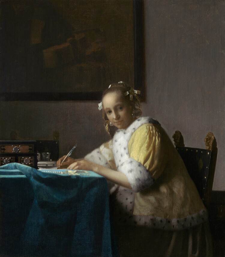Shown from about the knees up, a pale, smooth-skinned woman in a fur-lined yellow jacket looks out at us as she sits writing at a table in this vertical painting. The woman’s body faces the table to our left. She turns her head to gaze at us from the corners of her dark gray eyes under faint brows. She has a wide nose, and her pale lips are closed. Her light brown hair is pulled back and held in place with white bows, and gleaming teardrop-shaped pearl earrings dangle from her ears. Her lemon-yellow jacket is trimmed with ermine fur, which is white with black speckles, at the cuffs and down the front opening. A full, elephant-gray skirt falls to the floor beneath the jacket. Both hands rest on the table, and she holds a quill in her right hand, farther from us, on a piece of paper. She leans forward in her wooden chair. The back panel of the chair is covered in black fabric and lined with brass studs. Two gilded finials, carved into lions’ heads, face the woman’s back with mouths open. The table is covered with a celestial-blue cloth crumpled near the left edge of the canvas. On the table are a strand of pearls, a pale yellow ribbon, and a black box with three brown panels studded with pearls around silver keyholes. Two pewter gray vessels are visible just beyond it, in front of a second chair, which faces us. On the putty-gray wall behind the woman, a framed painting hangs in the upper left quadrant of the composition. The painting-within-the painting is done in muted tones of brown and shows a cello and other unidentifiable objects.