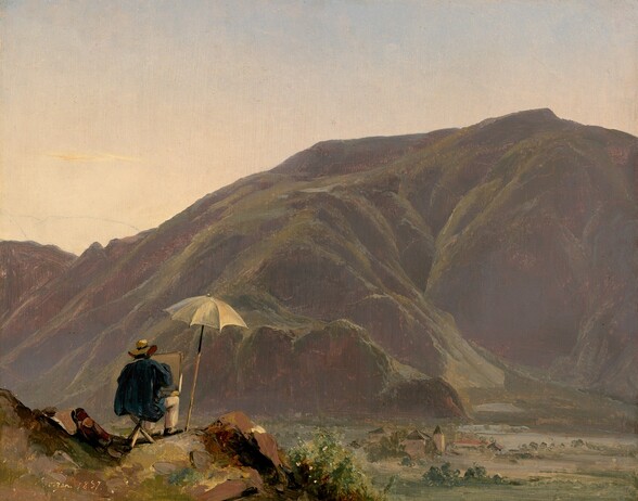 Perched on a rocky outcropping in the lower left corner of this landscape, a person sits with their back to us with a canvas near their knees, facing a moss-green, craggy mountain that fills most of our view this horizontal scene. The person wears a floppy-brimmed, straw-yellow hat and a teal-blue smock. He has cream-white pants and black shoes, and sits on a three-legged stool. A canvas rests on or just beyond his knees, and he holds one hand up to its blank surface. A tall, parchment-white umbrella is pitched next to him, to our right, to provide some shade. A few swipes of brick red, brown, and pinkish beige next to him could be bags or other materials leaning against a rock. He sits in the curve of the rocky outcropping, which is painted with dabs and swirls of olive green, butter yellow, and ginger brown. A valley stretches out between the painter and the mountain. Meadows in the valley are painted with pale sage green, and a cluster of tan buildings sits near the edge of an ice-blue body of water. The hill rises steeply from the valley. It dips a bit to our left and comes more than three-quarters up the composition to our right. It is painted in hazy, muted tones of moss green, mauve purple, and smoke gray. The sky deepens from pale lemon yellow along the horizon through light peach to muted blue along the top edge. The artist signed and dated the work in the lower left corner, “Botzen. 1837.”