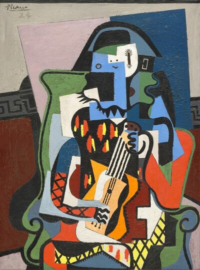 Geometric and wavy shapes in areas of flat color come together as a person holding a small guitar, sitting on a green chair, in this vertical, abstracted painting. Some of the forms are outlined in black. Two dots and a curving line read as a modern smiley face on the person’s head, but a circle to our left and a tall, long oval to our right could be the eyes. The tall oval has short, cilia-like rays at the top and bottom, perhaps eyelashes. Pointed triangles along the bottom of the head area could be a beard or mustache. A shallow, upside-down, black U over the head is filled in with slate blue, and is presumably a hat. Areas on the torso have black grids creating diamond patterns against tomato red or bright yellow. Another area has vertical red and yellow dashes against a black background. Together they read as a diamond-patterned costume. The guitar is held vertically on the lap. It has an oversized neck vertically striped with black and white, an orange body with slivers of white to our left and black to our right. One hand holds the guitar near the tuning pegs and the other, represented with three wavy lines for fingers, touches the strings below. The chair behind the musician is grass green, and has curving sides and scrolling arms. The background behind the chair has vertical petal-pink and ocean-blue rectangles, against a wall that is off white above and rust brown below. The two zones of the wall are separated by a band with a Greek key pattern in charcoal gray and black. The artist signed and dated the top left corner, “Picasso 24.”