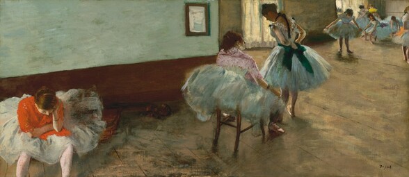 A long, brightly lit room is filled with at least nine young ballerinas in robin’s egg-blue dance costumes and pale pink shoes in this wide, horizontal painting. They all have light skin and brown or dark blond hair. The studio is lit from the left, and more light pours in through two windows toward the back. The wall closest to us is mint green with brown wainscoting covering the lower half, and a small mirror hanging a short distance down the wall. The walls of the space farther from us and the scuffed, worn floor are both painted with tan layered with washes of moss green and denim blue. A dancer in the lower left faces us and sits near a cello lying on the floor. The instrument’s curved upper body and neck emerge from the tutu near her left hip, on our right. She leans forward with her right arm, on our left, draped across her lap, and she rests her head on the other hand, propped up on her elbow. We look slightly down on her so only see the top of her head and the point of her nose. She wears a red jacket with her ice-blue, knee-length tutu spread around her. Her splayed feet are cropped by the bottom edge of the canvas. In the center are two dancers, one seated and the other standing. The seated girl is perched on a wooden chair with the back of her tutu draped over its top. She also wears a petal-pink jacket dotted with darker mauve. She gazes at the girl in front of her. That girl stands with her back to us, bowing her head slightly as she adjusts the bow of her emerald-green belt at the small of her back. At least six more dancers sit or stand along the far wall, in the upper right corner of the composition. One looks down at her tutu spread wide between her hands, and another holds a canary-yellow fan up to her face. The features of this group are loosely painted, making them indistinct. The artist signed the lower right, “Degas.”